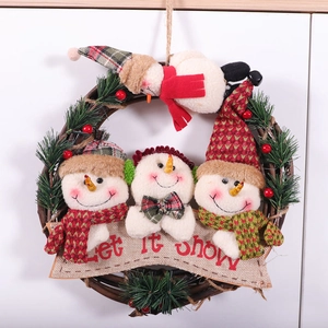 Christmas wreath with plush snowmen berries and pine needles on a rattan base