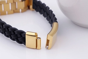 Macro shot of gold-plated magnetic clasp on a black braided leather wristband