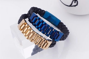 Close-up of black braided leather men's bracelets with gold and blue stainless steel buckles
