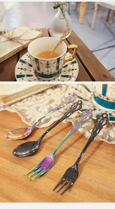 Close-up of vintage embossed dessert spoons and fruit forks in rainbow and black finish