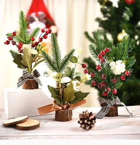 Detailed view of mini Christmas trees with pine cones, red berries and wooden bases