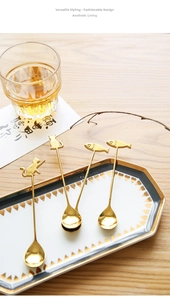 Macro view of four golden 304 stainless steel dessert spoons with cat and fish handles