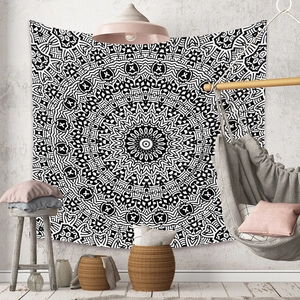 Tapestrie mandala bohème noir et blanc suspendue dans un salon chaleureux