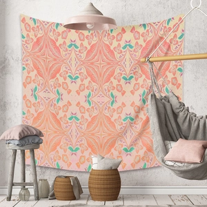 Détail d'une tapisserie mandala bohème avec motifs floraux orange et rose sur un mur