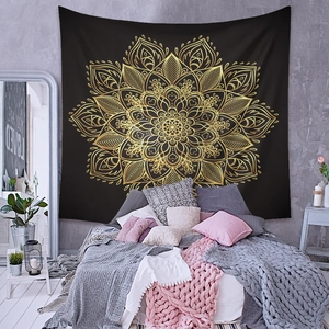 Détail d'une tapisserie mandala bohème noir et or suspendue au-dessus d'un lit moderne
