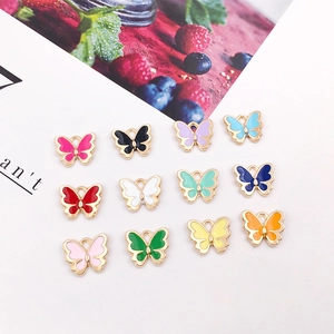 Flat lay of colorful butterfly alloy pendants in twelve enamel shades for DIY jewelry making