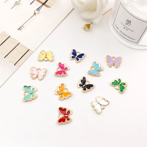 Macro detail of twelve colorful butterfly charms with gold-plated edges for DIY jewelry