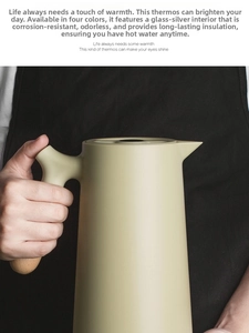 Detail of light olive green coffee carafe with silver-plated glass liner and wood handle