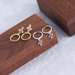 Macro shot of gold and silver S925 sterling silver cross earrings with colorful zircon stones