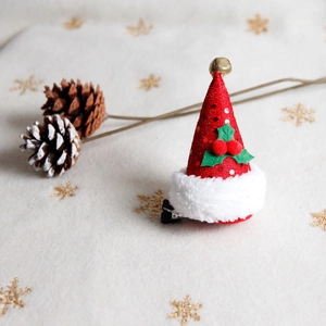 Christmas hair clip with mini red sequin Santa hat, gold bell, and green leaves decor