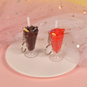 Detailed view of chocolate and strawberry sundae keychains on a decorative tray