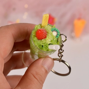 Close-up of realistic green sundae keychain featuring a mini cherry and kiwi slice