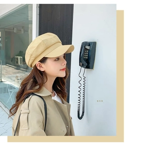 Detailed side view of beige cotton linen newsboy hat worn by a model in outdoor setting