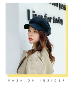 Close-up of a stylish black cotton-linen newsboy cap worn by a model in a urban setting