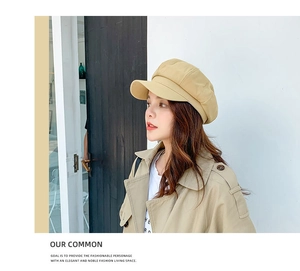 Detail view of khaki cotton linen octagonal hat paired with a stylish trench coat