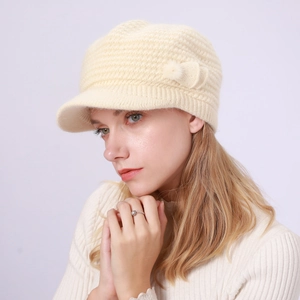 Detail der beige Strickmütze mit Schirm, Wollmuster und seitlichem Schleifendesign