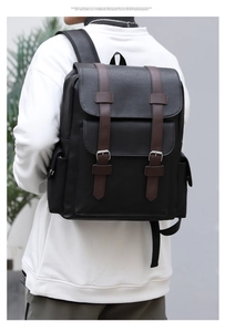 Detailed back view of a large black PU leather backpack with brown straps on a model