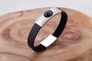 Close-up of black braided leather bracelet with stainless steel plate and black gemstone