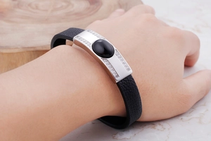 Detail of men's leather bracelet with silver metal plate and black oval stone inlay