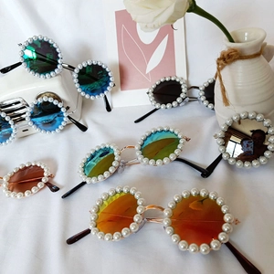 Chic round pearl-embellished flower sunglasses in multiple colors on white fabric