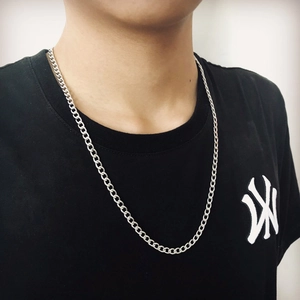 Close-up of polished silver stainless steel Cuban link chain necklace on a model