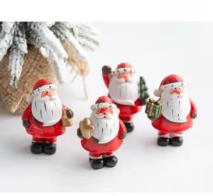 Close-up of four resin Santa Claus miniatures with bells, stars, and tiny Christmas trees