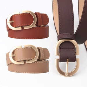 Detailed view of women's leather belts with golden D-rings in brown, beige, and tan