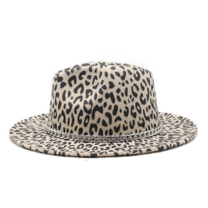 Détail du chapeau fedora léopard avec une grosse chaîne argentée sur le bord large