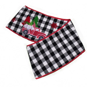 Détail du chemin de table de Noël à carreaux avec gnome et motif de camion rouge