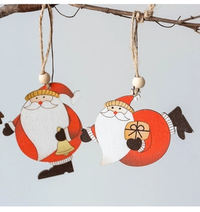 Detail of wooden Santa ornaments with bells and gift boxes hanging on natural branches