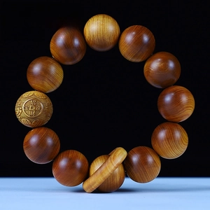 Close-up of 20mm aged Thuja wood beads with engraved Chinese character for wealth and luck