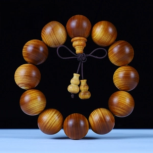 Macro detail of 20mm Thuja wood beads with natural grain and small gourd pendants