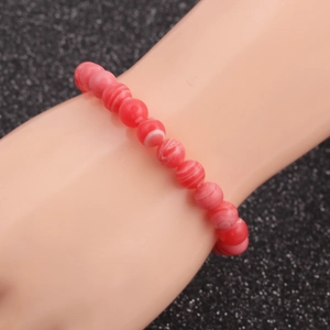 Pink striped agate bead bracelet with white wave patterns on a wrist model display