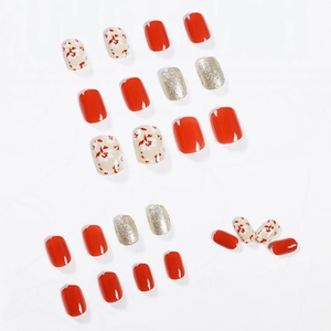 Red and gold floral press-on nails set with red floral patterns on a white base