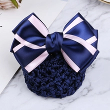 Detail of blue and pink ribbon bow hair clip with crochet mesh net on marble