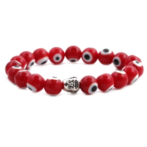 Detailed view of red evil eye beads and vintage silver Buddha charm on elastic bracelet