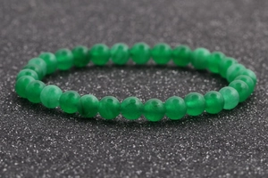 Primer plano de pulsera de cuentas de ágata verde de 6mm sobre fondo oscuro