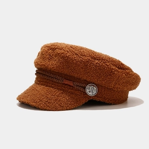 Close-up of brown faux shearling baker boy hat with braided cord and vintage silver button