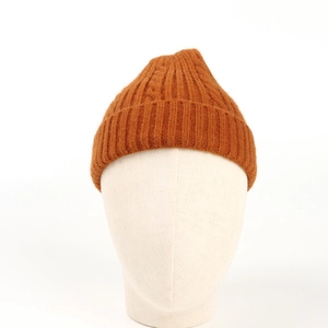 Detail of caramel knit beanie showing thick ribbed texture and wide folded brim for warmth