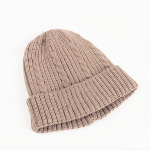 Close-up of light brown cable knit beanie showing thick texture and ribbed cuff