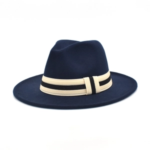 Detail of navy wool fedora hat with a beige striped decorative band around the crown