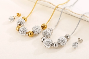 Détail d'un ensemble de bijoux en or et argent avec boules en cristal et chaînes serpent