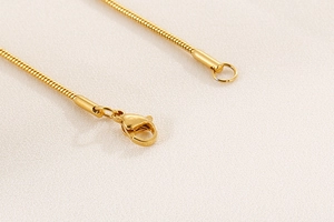 Détail du fermoir mousqueton en acier inoxydable doré et fermeture du collier