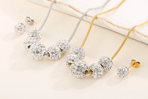 Détail d'un ensemble collier et boucles d'oreilles en acier titane et boules zircon