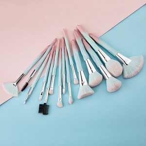 Flat lay of 13 gradient pink and blue diamond makeup brushes with soft synthetic bristles