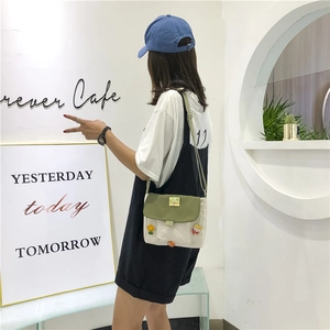Sac bandoulière en toile style japonais avec écusson floral porté par un mannequin