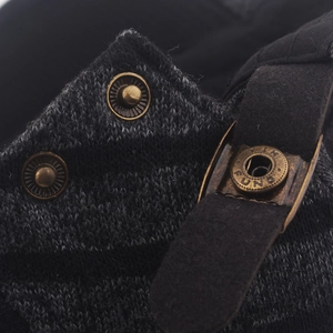 Dettaglio di bottoni a pressione vintage e anello YIK FUNG su berretto in maglia grigia