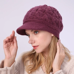 Detalle del gorro de punto violeta oscuro con patrón de trenzas y protección de orejas