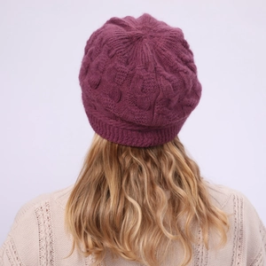 Detalle del gorro de punto violeta oscuro con patrones de trenzas y textura de invierno