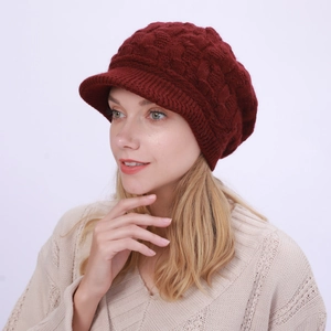 Detalle del patrón de punto de ochos granate y visera en el gorro de punto de invierno